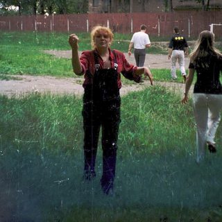People playing water games outdoors in grassy area.