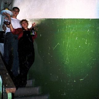 Two people standing on stairs holding drinks.