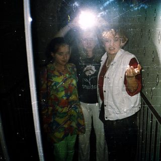 People in an elevator with one person pointing.