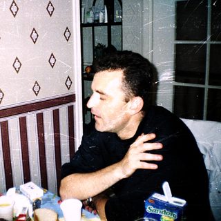 Two people having a meal indoors, pointing and laughing.