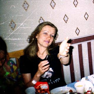 Two people having a meal indoors, pointing and laughing.