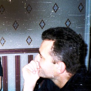 Three people laughing indoors during a social gathering.
