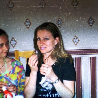 Three people laughing indoors during a social gathering.