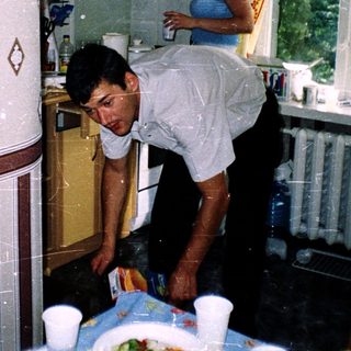 Two people cleaning a kitchen with water.