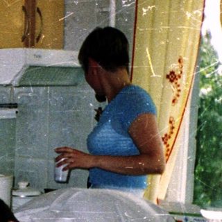 Two people cleaning a kitchen with water.