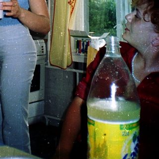 Woman pouring coffee in kitchen with child.