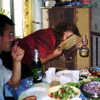 Family gathering enjoying meal and drinks indoors.