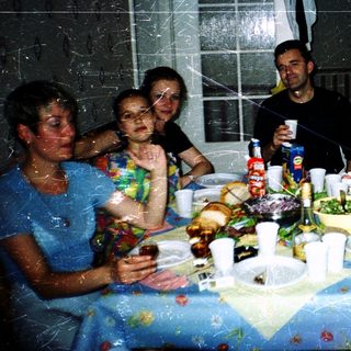 Group celebrating indoors with food, drinks, and confetti.