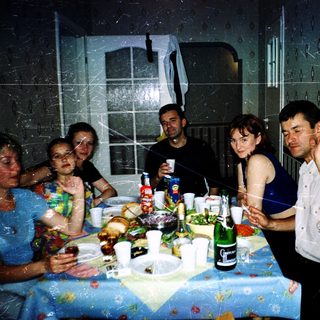 Group celebrating indoors with food, drinks, and confetti.