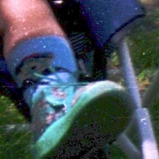 Baby riding a swing in backyard.