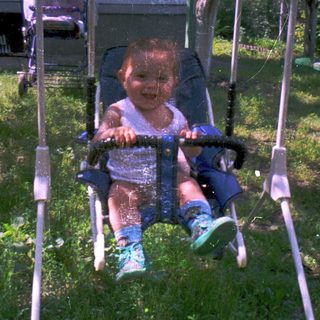 Young child happily swinging in outdoor swing.