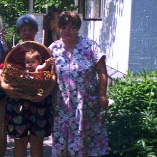 Four people posing outdoors with a basket.