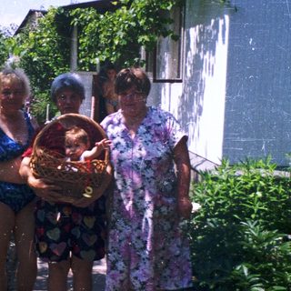 Four people posing outdoors with a basket.