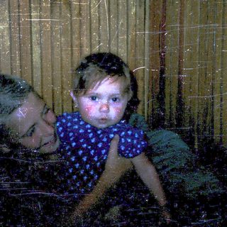Two people, likely mother and child, playing in water through a window.