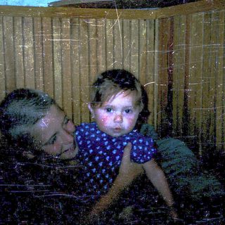 Two people, likely mother and child, playing in water through a window.