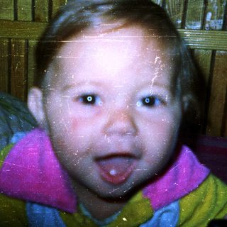 Young child with tongue out, blurred background.