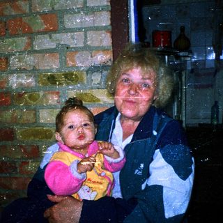 Wet woman holding baby indoors during rain.