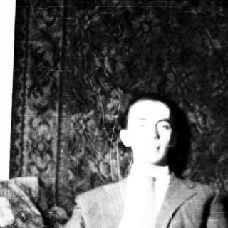 Blurred black-and-white portrait of a man in suit.