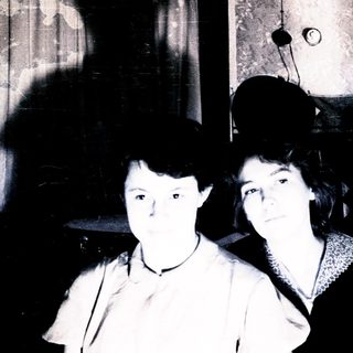 Two individuals posing indoors, mid-20th century.