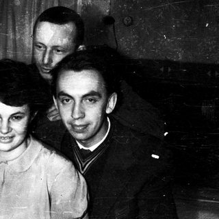 Three people posing indoors, mid-20th century.