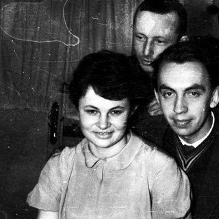 Three people posing indoors, mid-20th century.