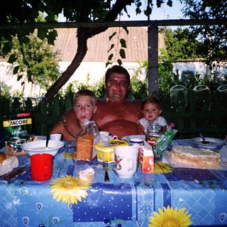 Family picnic or outdoor meal with food and drinks.