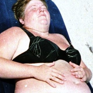 Person relaxing on beach lounger.