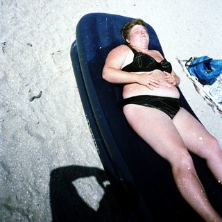 Person relaxing on beach lounger.