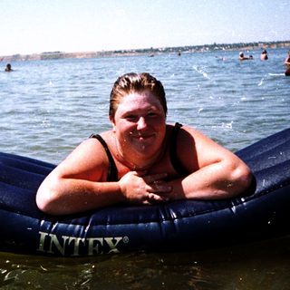 Person enjoying inflatable float in ocean water.