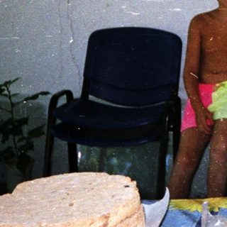 Three children posing indoors near food items.