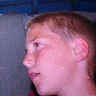 Boy looking up at tree-covered roof.