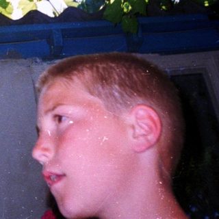 Boy looking up at tree-covered roof.