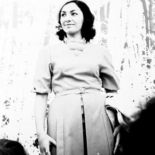 Elegant woman in formal attire posing indoors.