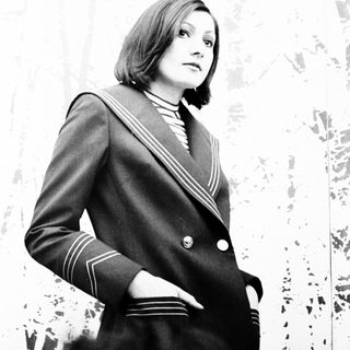 Formal portrait of woman in naval-style blazer.