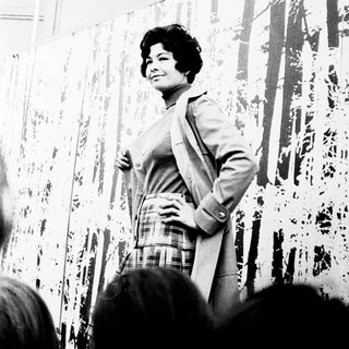 Confident woman speaking to an audience indoors.