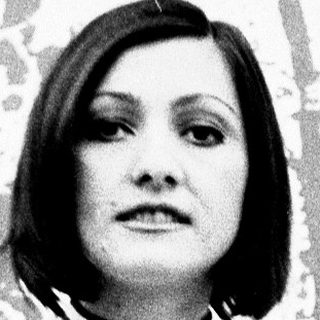 Woman in striped top standing indoors.