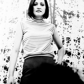 Woman in striped top standing indoors.