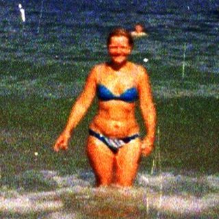 Woman swimming in stormy ocean waves.