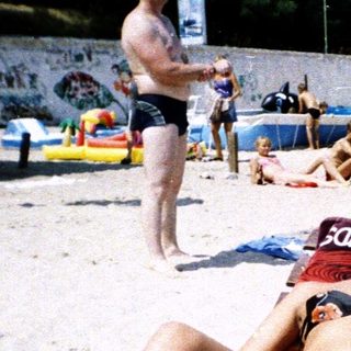 People sunbathing on beach loungers.