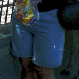 Woman feeding ducks by a water fountain.