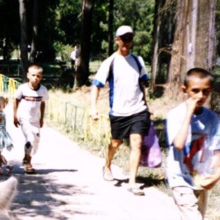 Children riding donkeys on a park path.
