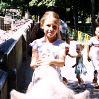 Children riding donkeys on a park path.