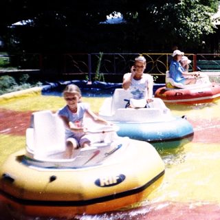 Children riding bumper boats in a water park.