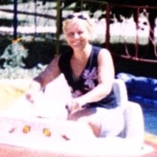 Two people riding bumper boats in water.