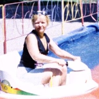 Person riding inflatable water bumper boat ride.