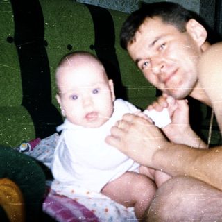 A man and baby posing indoors together.