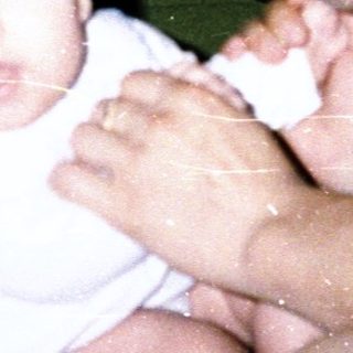 A man and baby posing indoors together.