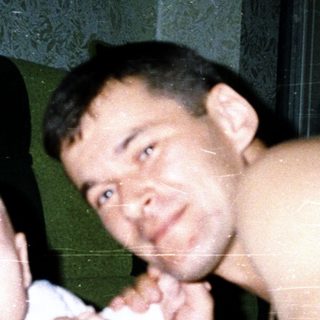 A man and baby posing indoors together.
