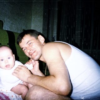 A man and baby posing indoors together.