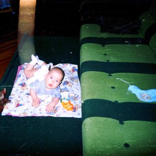 Baby lying on colorful blanket indoors.